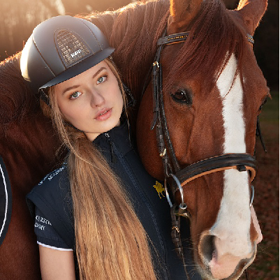Amazzone con casco insieme a cavallo marrone e bianco